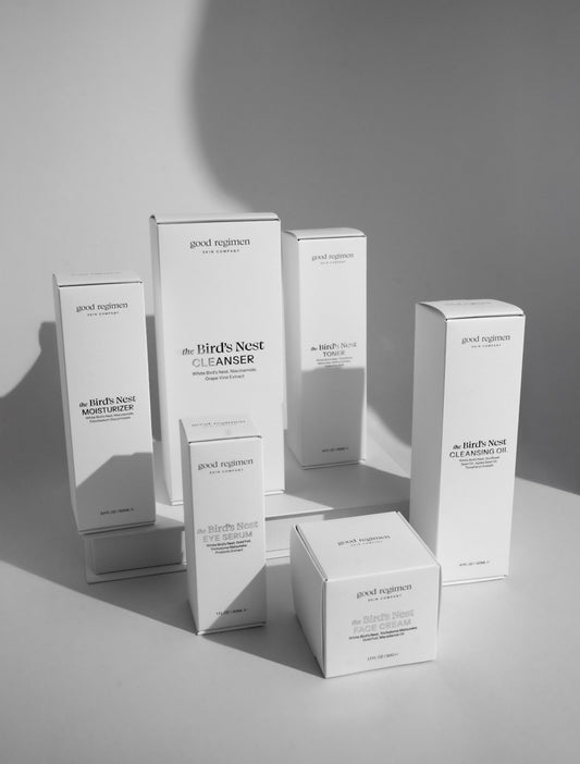 Good Regimen Bird’s Nest skincare collection in white product boxes, featuring moisturizer, eye serum, cleanser, face cream, toner, and cleansing oil in a clean minimalist studio setting with soft shadows.