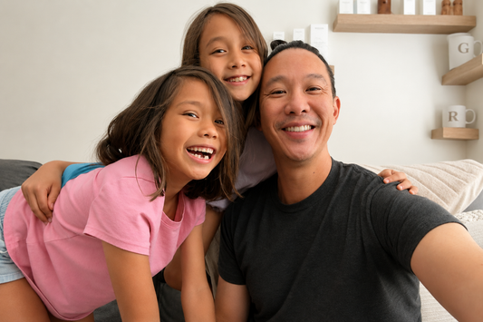 Good Regimen founder Clarence Ma smiling with his daughters for a parent guide about when kids should start skincare and building healthy skincare habits.